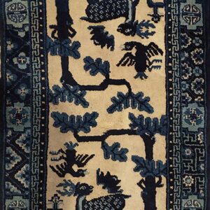 High-contrast cream and indigo blue rug featuring deer, trees, and detailed floral-geometric borders.