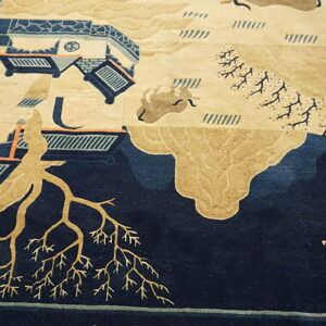 Low-pile rug with a complex beige and dark blue landscape design displayed on worn wooden planks.