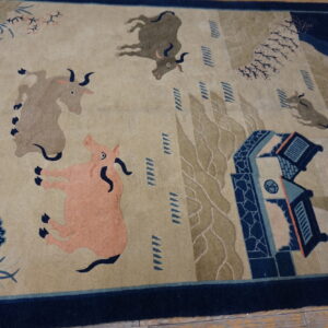 Beige and navy rug featuring oxen and a pink pig in a stylized scenic landscape on wood planks.