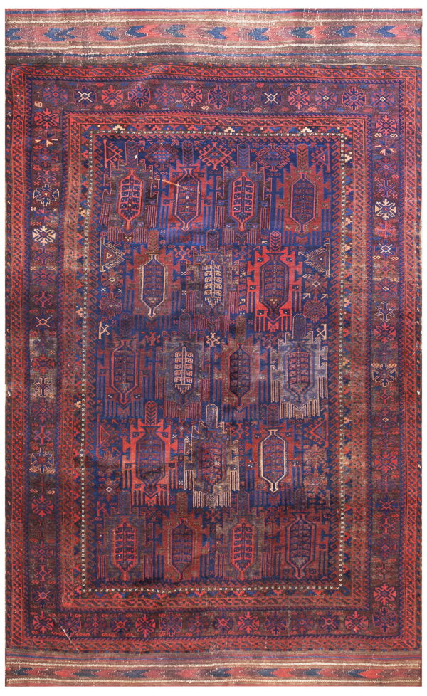 Faded geometric rug featuring complex tribal designs in dark blue and deep red colors.