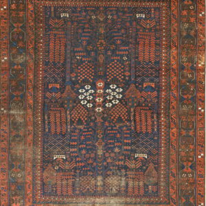 Heavily worn rug featuring a dark blue field with intricate rust and terracotta geometric patterns.