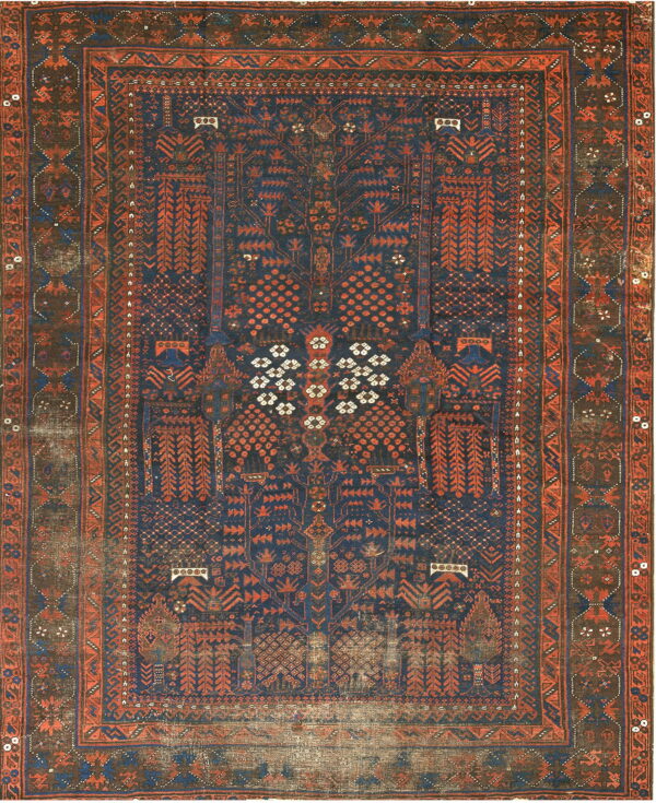 Heavily worn rug featuring a dark blue field with intricate rust and terracotta geometric patterns.