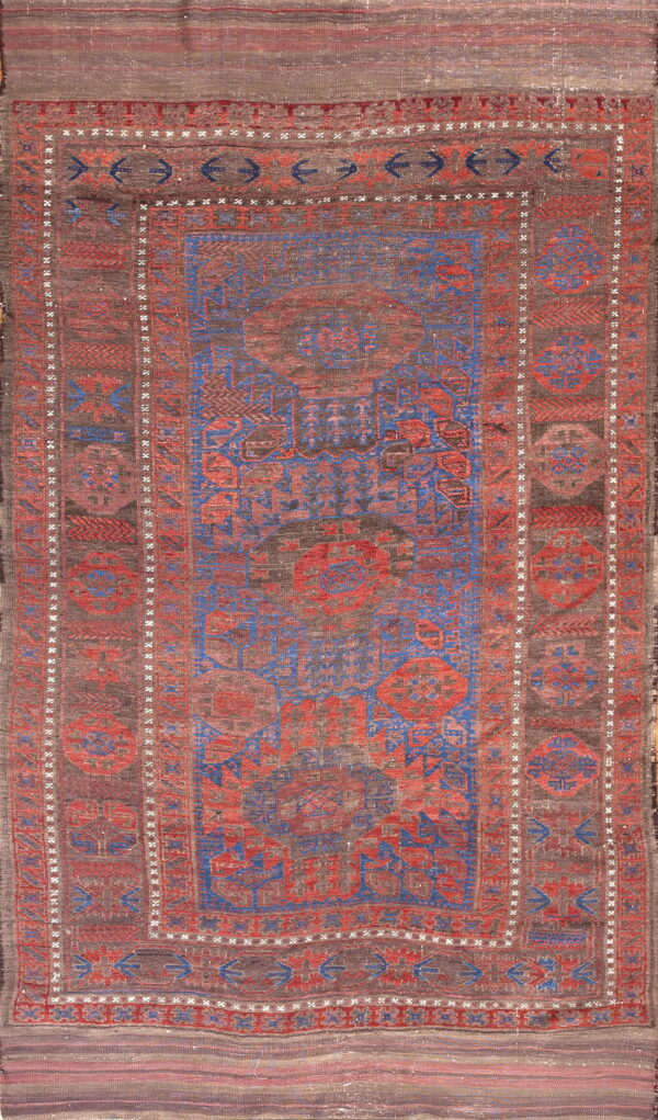 Geometric rug patterned in vibrant blue and red against a mottled dark brown ground.