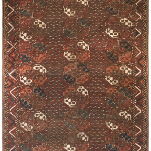 Distressed low-pile rug with geometric medallions in deep red, navy, and cream.