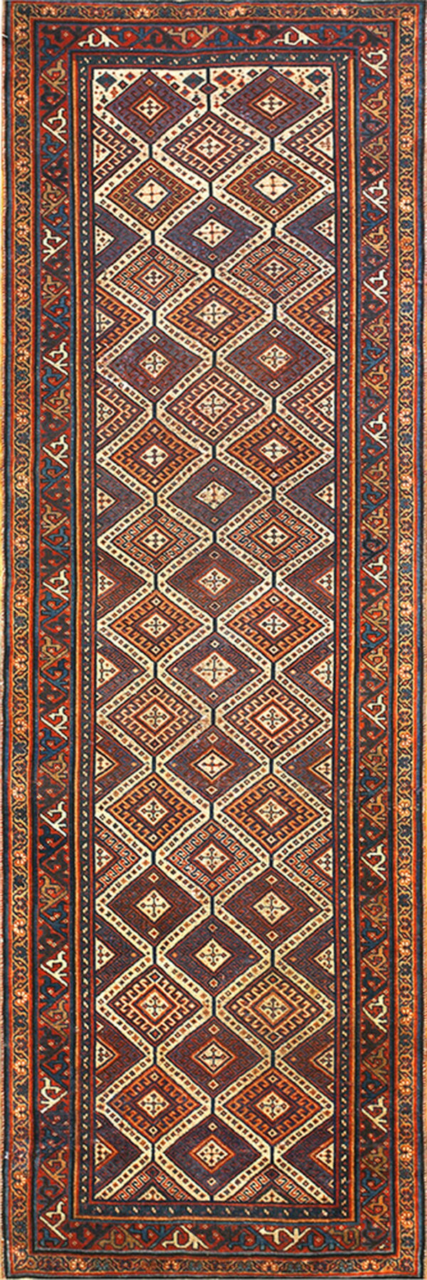 Geometric runner rug with repeating diamonds in navy, rust, red, and cream, framed by multi-layered borders.