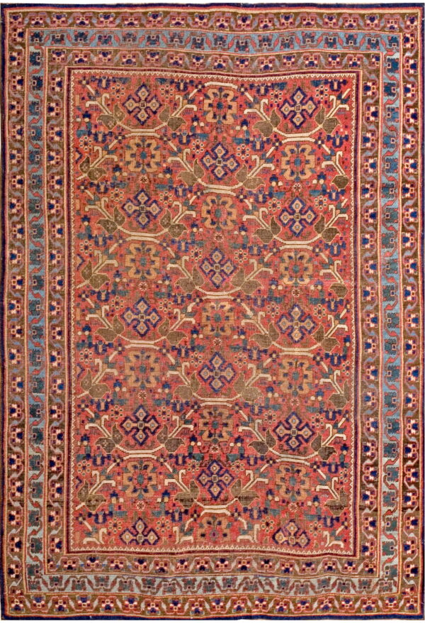 Muted red rug with a repeating geometric and stylized floral pattern in blue, olive, tan, and white.