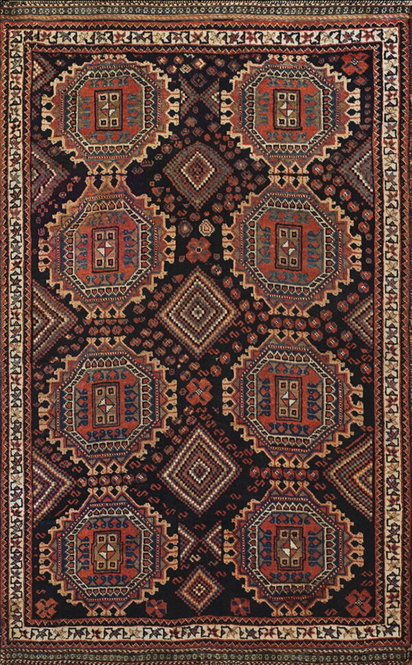 A geometric tribal rug with repeating terracotta and blue octagonal medallions on a dark navy background.