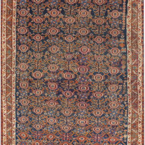 Dark blue rug with allover geometric patterns in terracotta, pink, orange, and light blue.