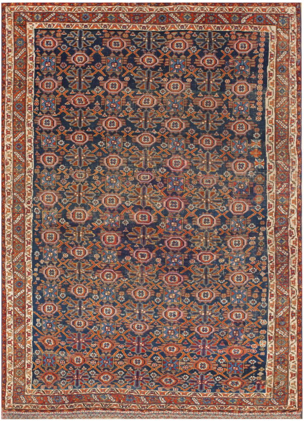 Dark blue rug with allover geometric patterns in terracotta, pink, orange, and light blue.