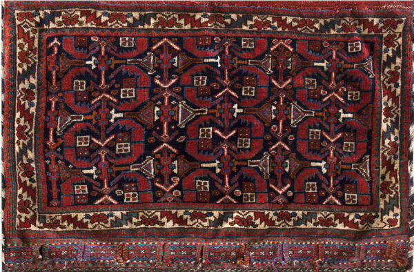 Geometric rug with deep red and navy blue repeating tribal motifs and a multi-banded border.