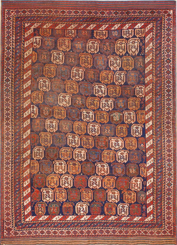 Geometric rug with an indigo field filled with repeating terracotta, beige, and blue medallions and striped borders.