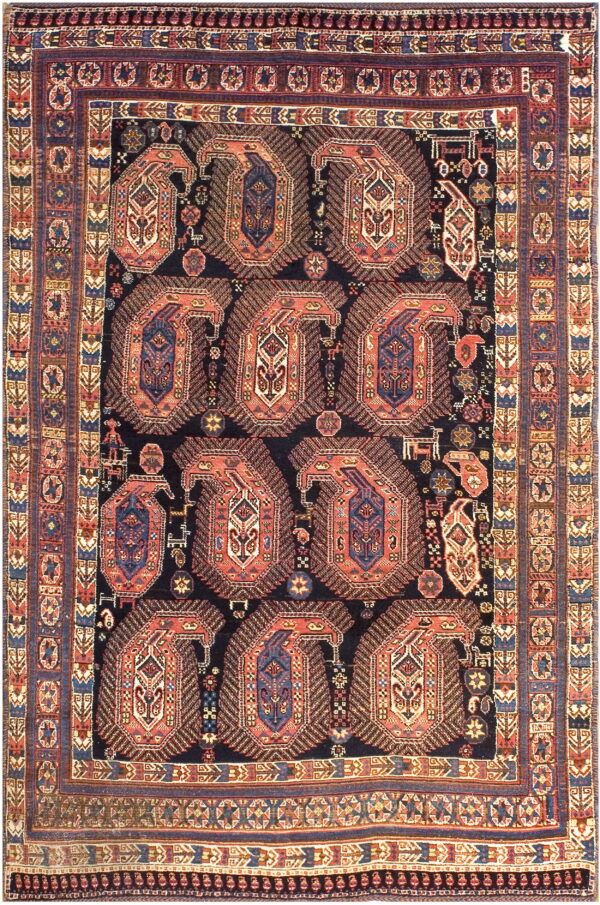 Navy blue rug densely patterned with nine large rust and blue boteh forms and complex geometric borders.