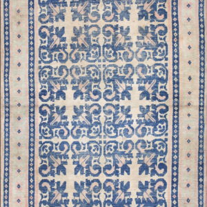 Cream rug with a bold blue and pink repeating geometric floral design and multiple borders.