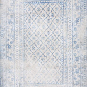 Light blue and cream rug with a faded look, complex geometric borders, and a repeating central trellis pattern.