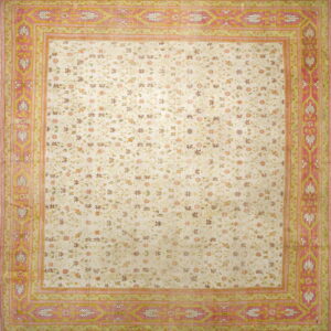 Cream rug featuring a delicate floral trellis pattern and a wide, detailed border in rose pink and sage green.