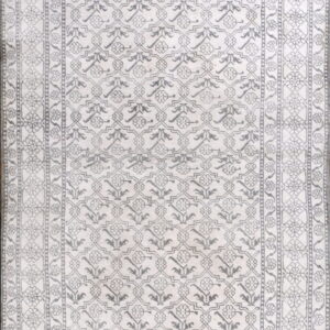 Monochromatic rug with intricate gray geometric and floral patterns covering a light off-white field.