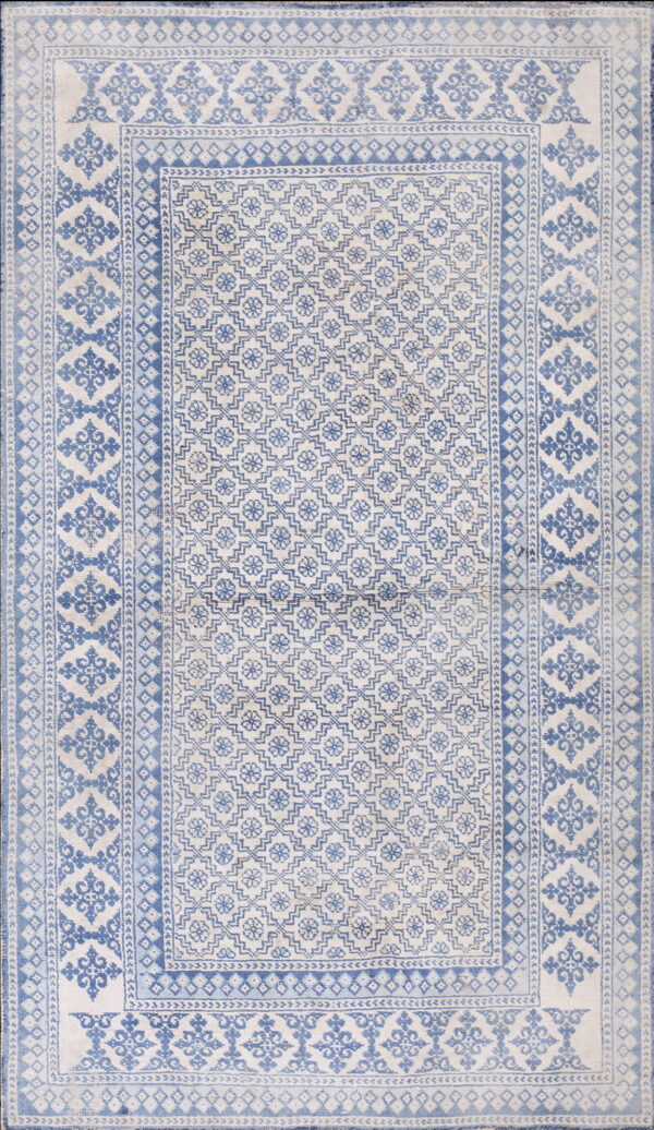 Light blue and white rug with a dense geometric field and multi-layered border design.