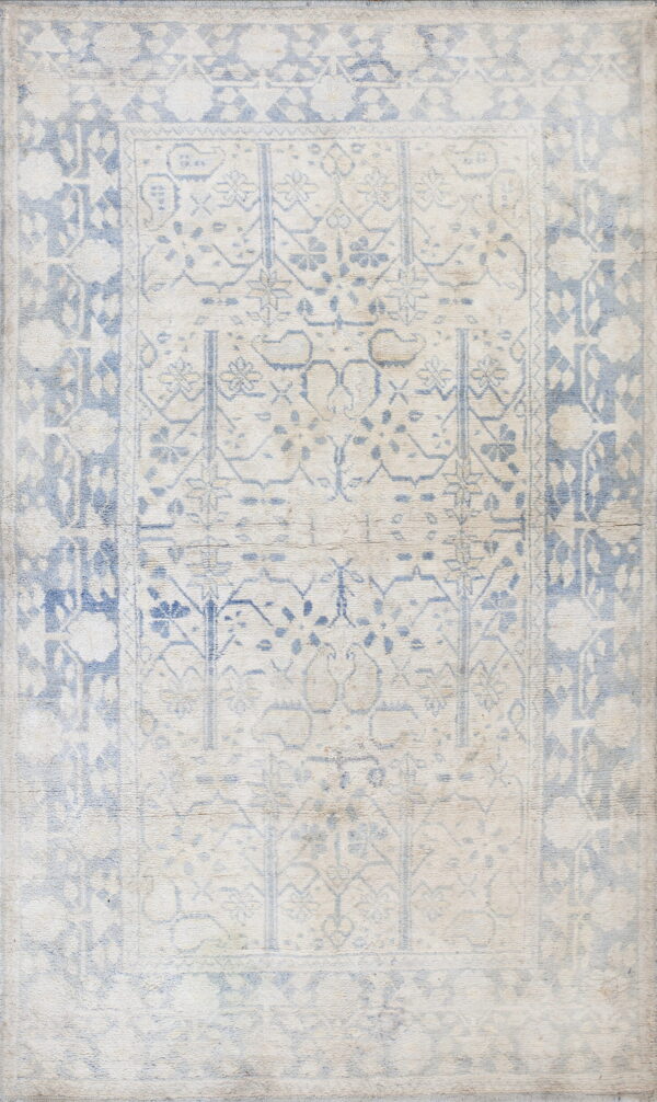 Faded cream and dusty blue rug with a distressed traditional field pattern and wide ornamental borders.