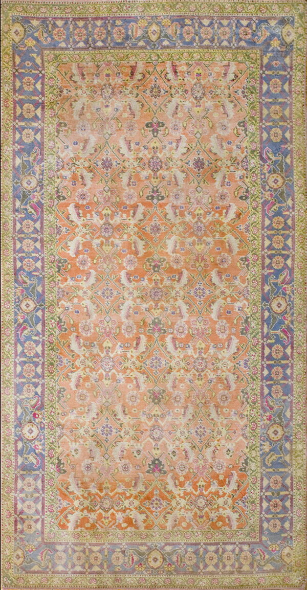 Traditional rug with an orange and peach field, surrounded by ornate blue and green floral borders.