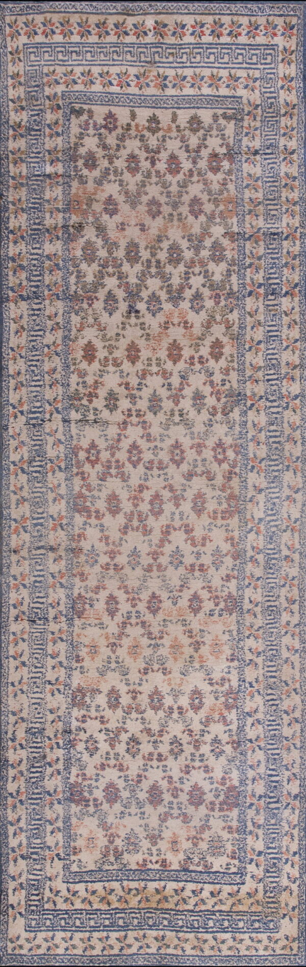 Cream runner rug featuring faded red and blue floral patterns framed by detailed blue geometric borders.
