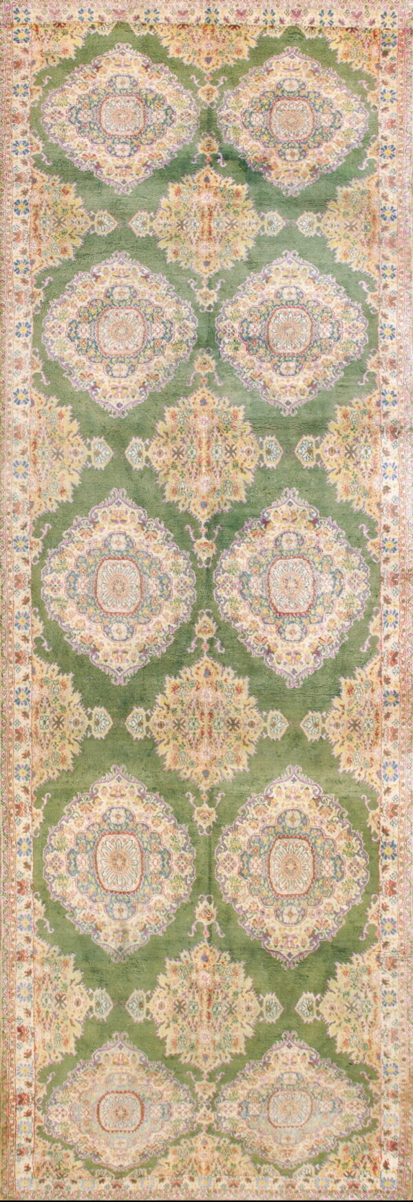 Long rug featuring repeating traditional floral medallions in cream and gold on a deep mossy green field.