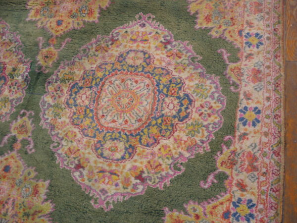 Shaggy rug featuring a vibrant medallion pattern in pink, yellow, blue, and cream on a moss green field.