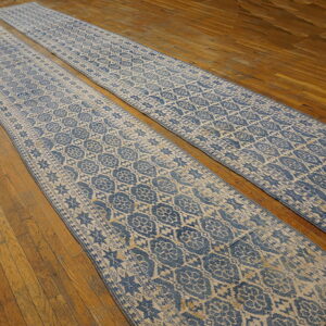 Two long blue and beige runners with a distressed medallion pattern lie parallel on a wood plank floor.