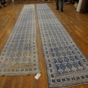 Pair of blue and tan patterned runner rugs with geometric medallions displayed on hardwood flooring.