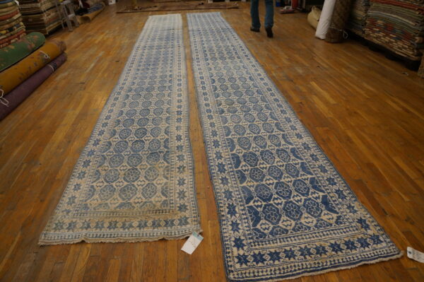 Pair of blue and tan patterned runner rugs with geometric medallions displayed on hardwood flooring.
