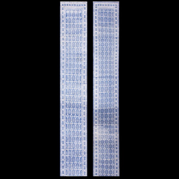 A pair of long blue and white runner rugs featuring intricate repeating medallion and star motifs.