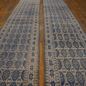 Two long blue and beige geometric runner rugs displayed on rustic wood plank flooring.