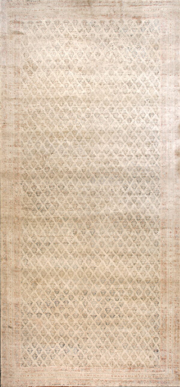 Narrow, distressed runner rug in cream and taupe featuring a repeating diamond lattice pattern.