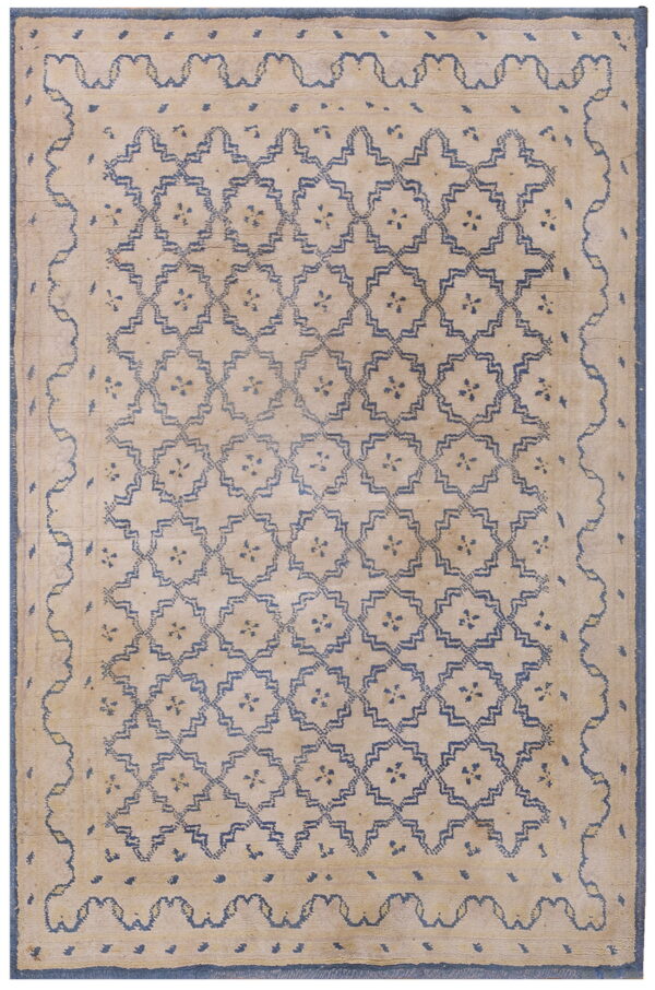 High-pile tan rug featuring an all-over dark blue geometric trellis pattern and thick blue borders.