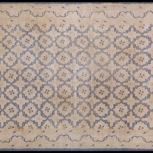 Low pile beige rug featuring an all-over blue geometric trellis pattern and a wide border with a wavy inner line.