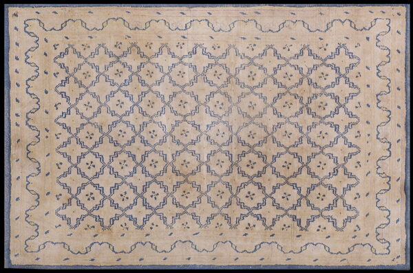 Low pile beige rug featuring an all-over blue geometric trellis pattern and a wide border with a wavy inner line.
