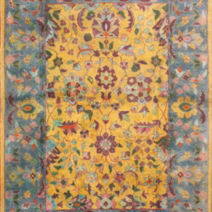 Ornate floral rug with a yellow center and a teal border, featuring maroon, pink, and green accents.