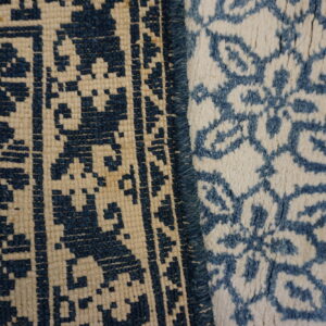 Detail of two blue and cream textures: a flatweave geometric pattern and a fluffy high-pile floral design.