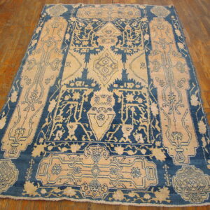 High-contrast blue and beige rug featuring an elaborate central medallion on glossy wood plank flooring.