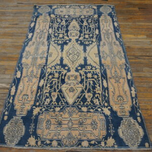 Geometric navy blue and beige patterned rug on wide, rustic wood plank flooring.