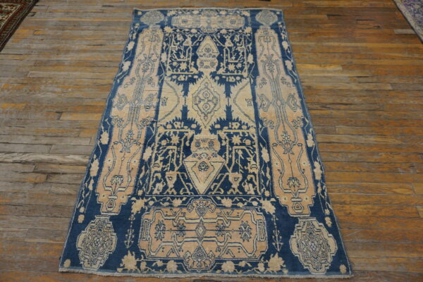 Geometric navy blue and beige patterned rug on wide, rustic wood plank flooring.