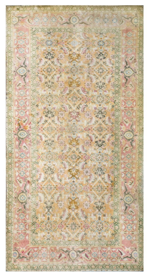 A distressed traditional rug featuring an apricot field with dusty pink, sage green, and blue floral motifs.