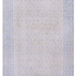 Off-white rug featuring a light blue Greek key border and a subtle geometric trellis central design.