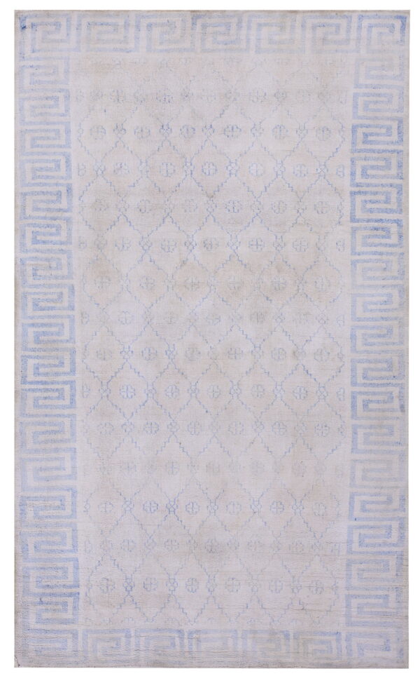 Off-white rug featuring a light blue greek key border and a subtle geometric trellis central design.
