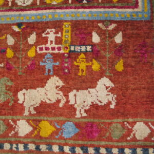High-pile red rug detail showing white, blue, and yellow stylized figures and green and white horses.