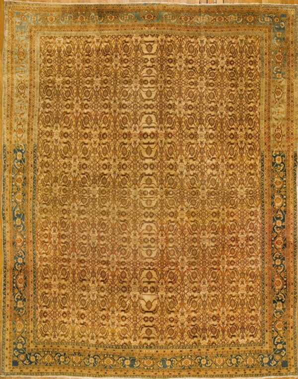 Large gold rug featuring a dense floral pattern framed by wide borders in teal and terracotta.