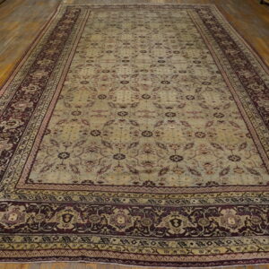 Large traditional rug with a pale green field and maroon border on light wood floors.