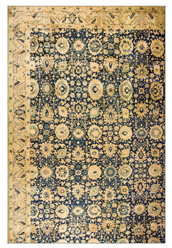 Dense blue rug pattern featuring stylized beige and blue floral motifs and a wide tan border.