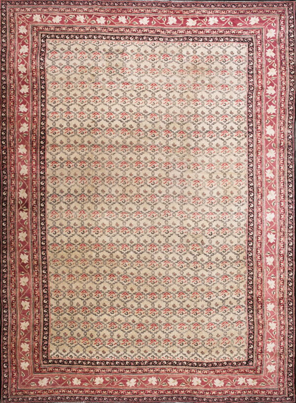 Cream rug featuring a repeating red and black trellis pattern and wide decorative red floral borders.