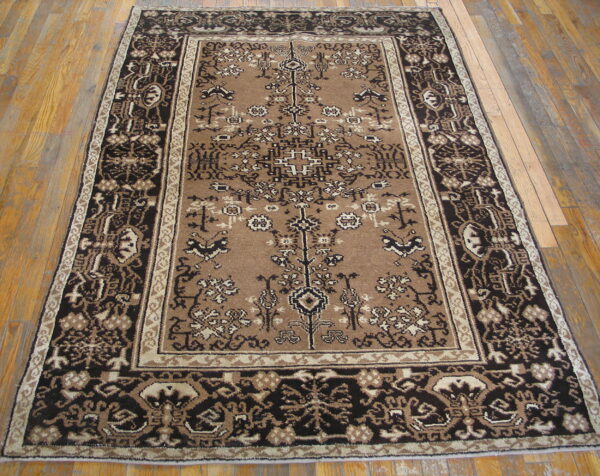 Rectangular brown rug featuring an intricate dark brown and tan traditional pattern on wood flooring.