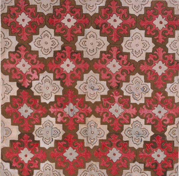 Textured rug with large repeating geometric medallions in red, brown, and beige on wood.